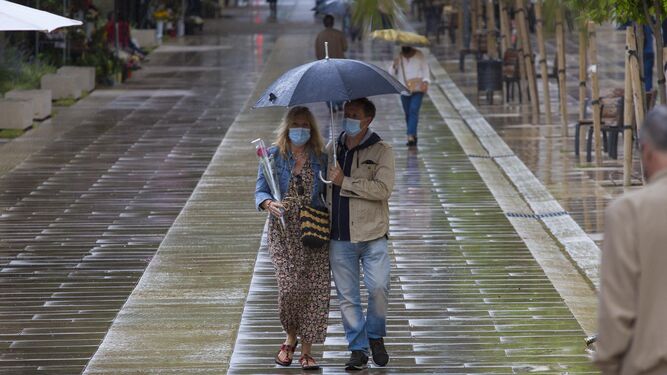 Una pareja se protege de la lluvia en Málaga capital.