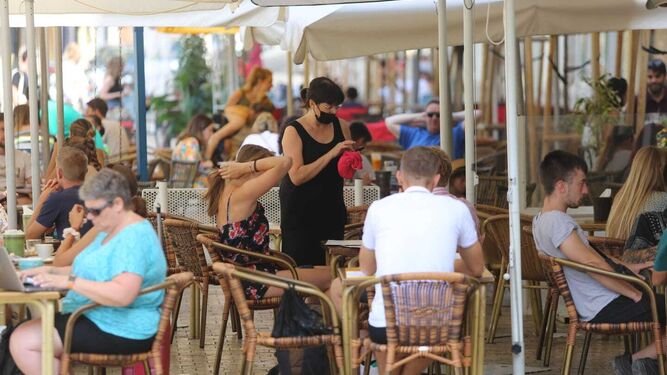 Una camarera toma nota a una pareja en una terraza de Málaga.