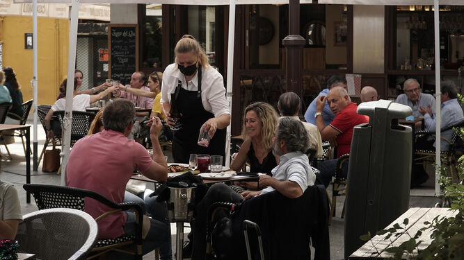 Una camarera atiende una mesa en Sevilla.