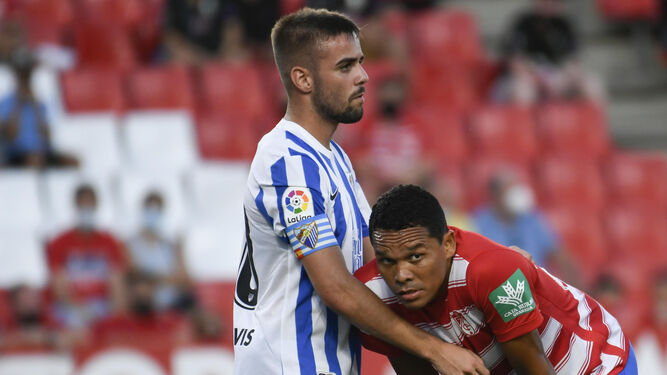 Ismael Casas defiende a Bacca en el Granada-Málaga CF.