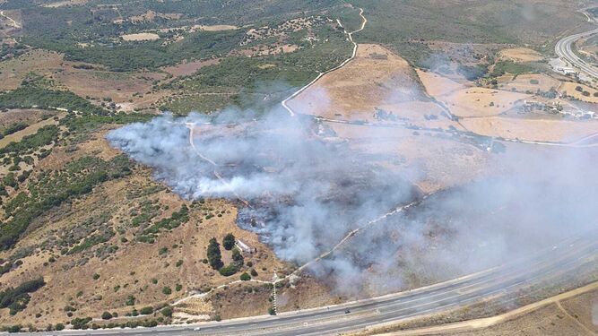 Un incendio forestal afecta a un paraje junto a un área de servicio de Manilva.