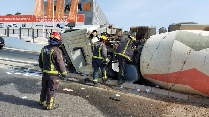 Bomberos en el accidente en el que ha volcado un camión hormigonera en Churriana, el pasado agosto.