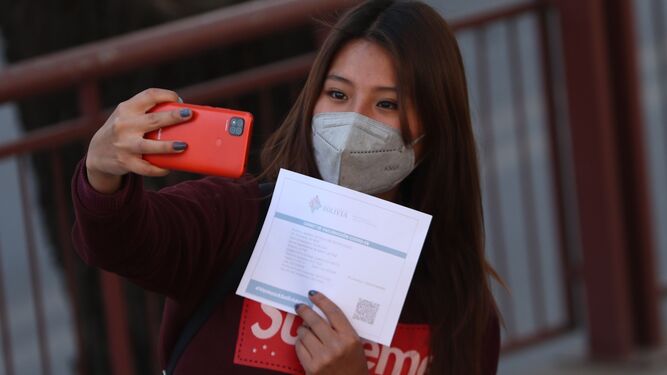 Una joven se hace un 'selfie' con su certificado Covid