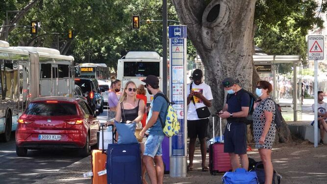 Turistas en una parada de autobús en Málaga.