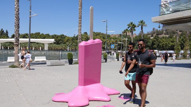 Dos turistas pasan junto a una escultura de un helado derretido, en Muelle Uno.