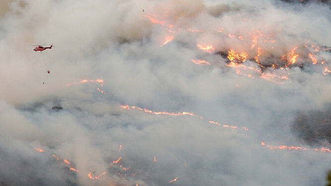 Un helicóptero intentando apagar el fuego en Sierra Bermeja.