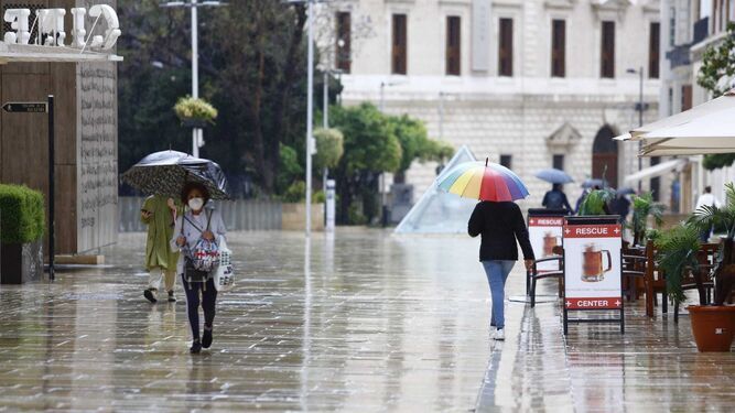 Varias personas caminan bajo la lluvia en Málaga.