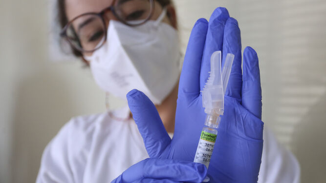 La enfermera posa con una vacuna contra la gripe.