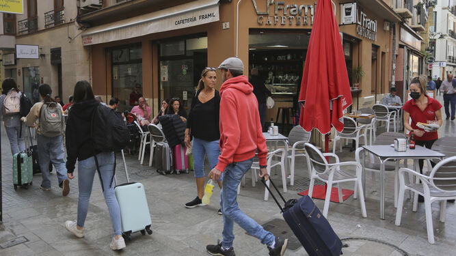 Un grupo de turistas pasean sus maletas por el Centro de Málaga.