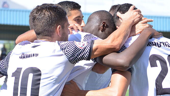 Jugadores del Vélez CF se abrazan.