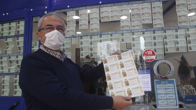 Hombre mostrando un décimo de lotería.