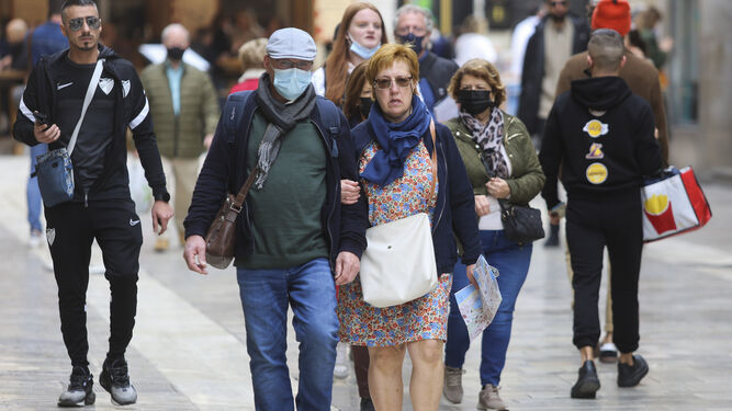 Personas con y sin mascarilla por el centro de Málaga.