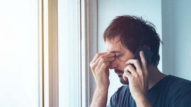 Un hombre atiende una llamada telefónica en la que podría estar siendo engañado