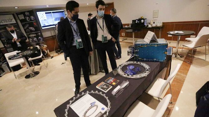 Dos profesionales observan uno de los satélites que se exponen en el congreso que se está celebrando en Málaga.