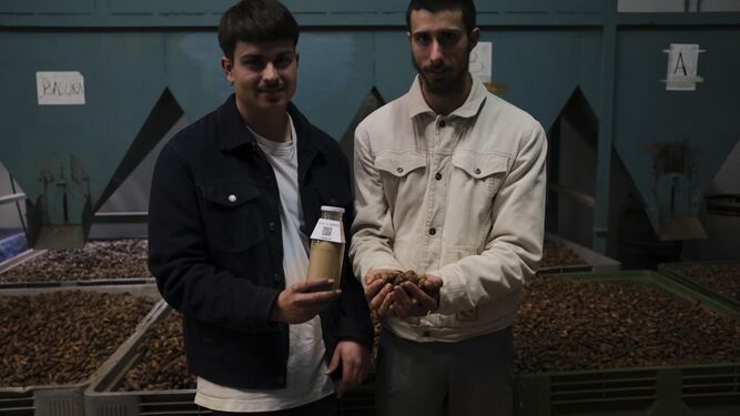 Pedro y Javier con una muestra de su leche de bellota en el secadero de Parauta.