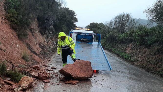 Un trabajador de la Diputación retira una roca desprendida sobre una carretera en Málaga.