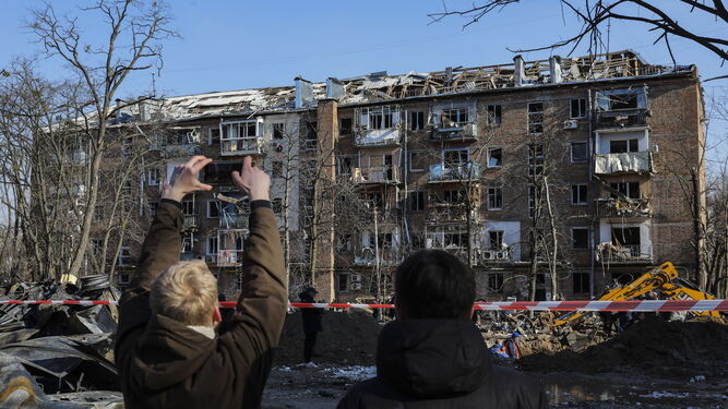 Un hombre toma fotografías de uno de los edificios destruidos por las bombas en Kiev, la capital de Ucrania.
