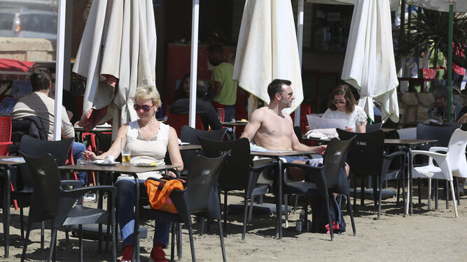 Varias personas disfrutan tomando el sol en un chiringuito en Málaga capital.