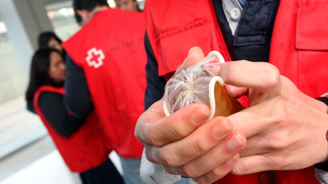 Un voluntario de la Cruz Roja muestra el uso de un condón.