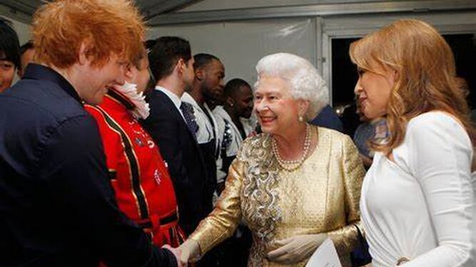 La reina Isabel II saluda al cantante Ed Sheeran en una recepción.