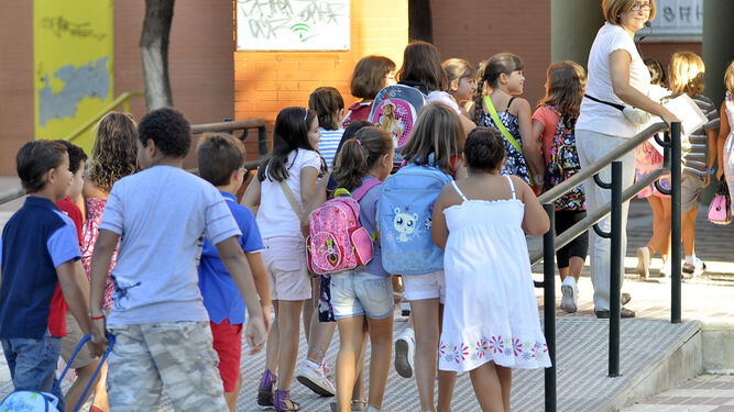 Niños entrando en un colegio el primer día de clase.