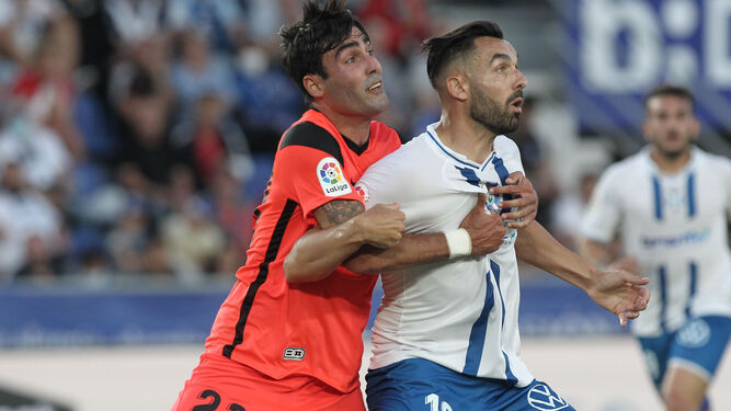 Albeto Escassi defiende a Enric Gallego en el Tenerife-Málaga CF.