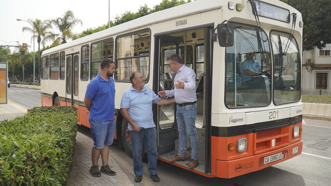 Representantes del PSOE con un antiguo autobús.