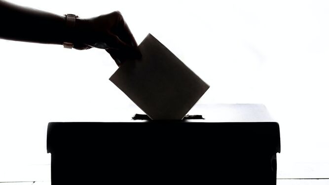 Una mano introduce un voto en la urna