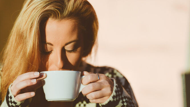 Una mujer bebe café.
