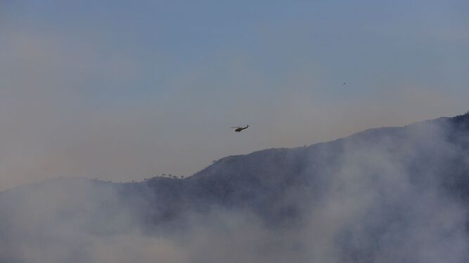 Un helicóptero sobrevuela la zona del incendio en Pujerra.