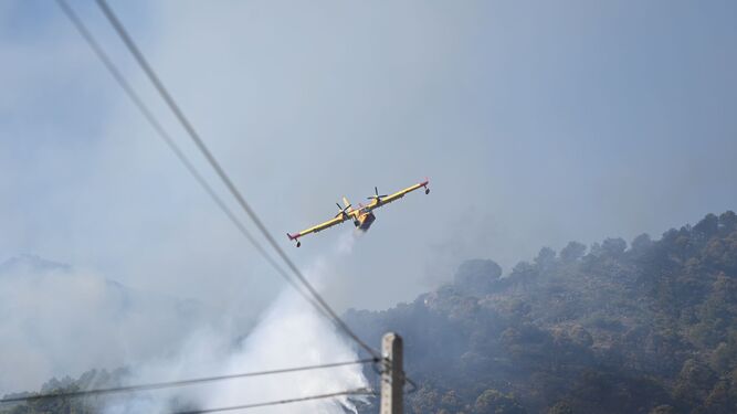 Un avión descargando agua en el incendio este domingo por la mañana.