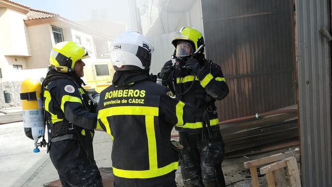Varios bomberos con los equipos de respiración autónoma, durante la intervención.