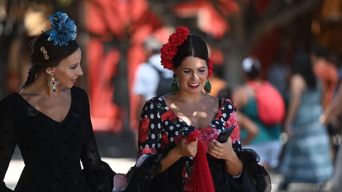 Dos amigas vestidas de gitana en el recinto ferial de Cortijo de Torres este lunes.