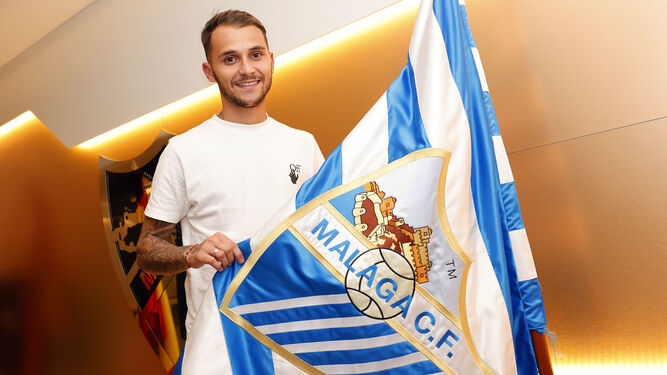Fran Villalba posa con la bandera del Málaga CF.