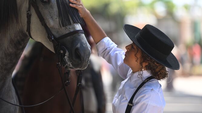 Una jinete acaricia a su caballo este jueves en el Real de la Feria de Málaga.