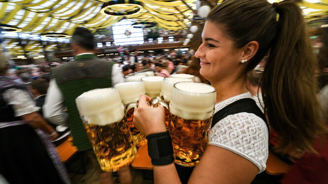 Una mujer carga con jarras e cerveza en el Oktoberfest de Múnich.