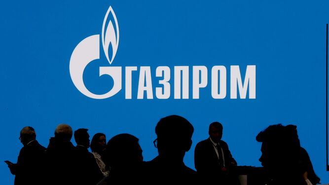 Varias personas ante el logo de Gazprom en el Foro Internacional del Gas de San Petersburgo.