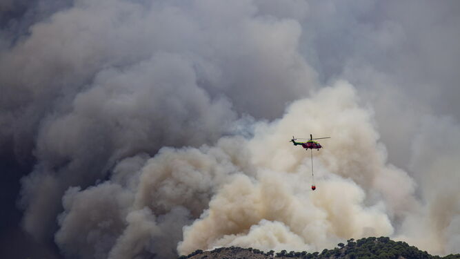Un helicóptero trabaja durante las tareas de extinción del incendio  declarado en Mijas.