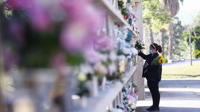 Una mujer lleva flores a sus familiares en Parcemasa.