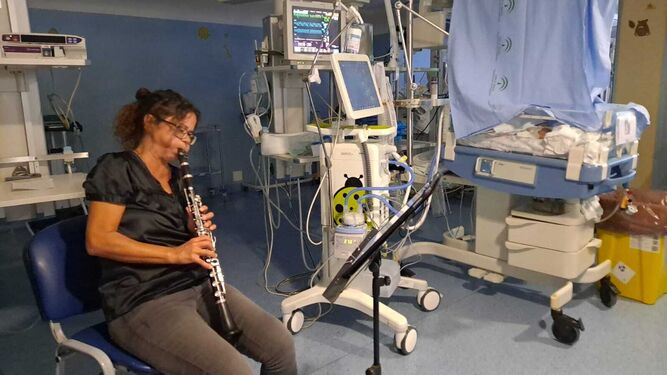 Marión Guaita toca música para un bebé como parte de las actividades del Día del Prematuro, en el Materno.