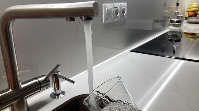 Un gripo de una cocina con agua corriente.