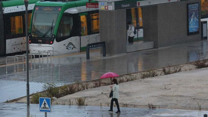 Una mujer se protege con un paraguas camino de la parada del Metro.