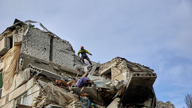 Miembros de los equipos de rescate trabajan en un edificio destruido por un bombardeo nocturno en la región de Jarkov.