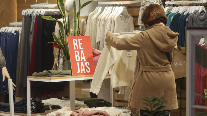 Una mujer en el interior de una tienda de Málaga capital que ya anuncia las rebajas.