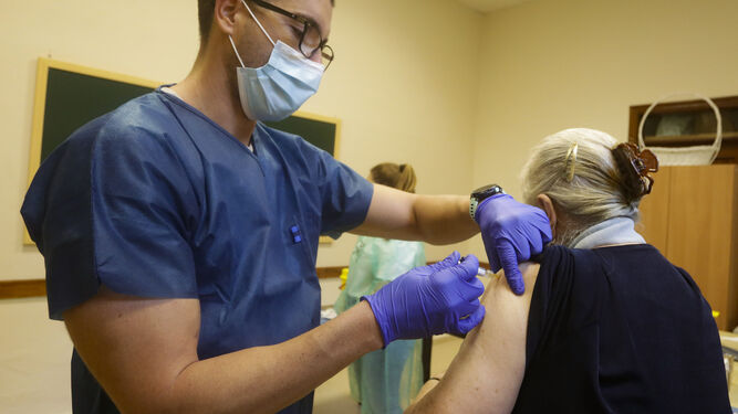 Un enfermero vacuna a una mujer contra la gripe.