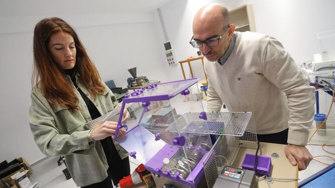 Los investigadores, Carmen Ladrón de Guevara y Óscar de Cózar, utilizando la máquina trituradora de 'Marea Plastic'.