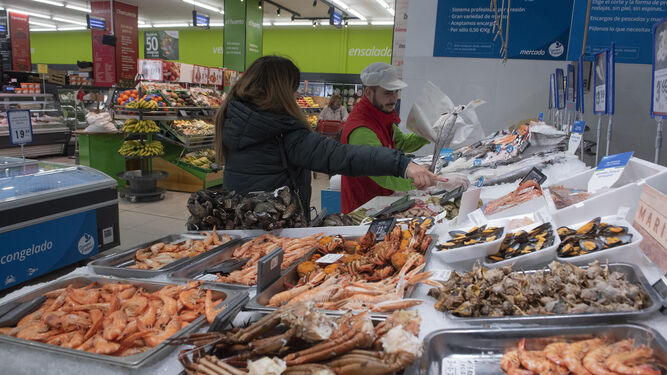 Un empleado del Grupo Mas atiene a una clienta en la sección de pescadería de uno de los últimos supermercados inaugurados en Sevilla.