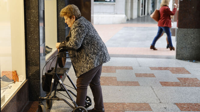 Una mujer pensionista mira un escaparate