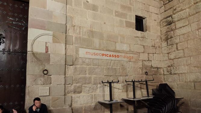 Fachada del Museo Picasso este Domingo de Ramos con mesas y sillas de una terraza plegadas junto a la fachada.