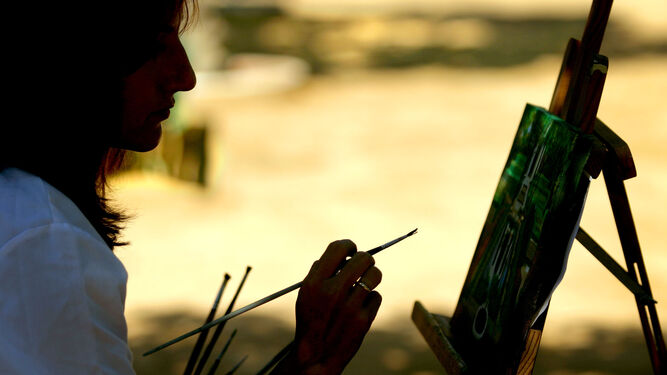 Una pintora realizando una obra en la calle.